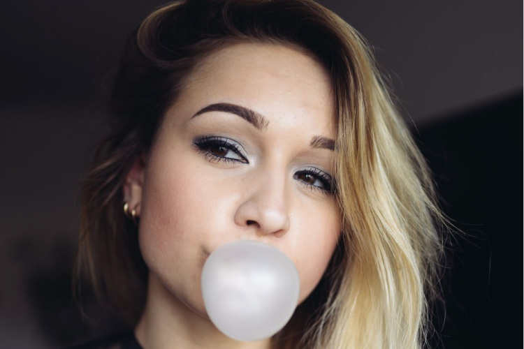 blond girl blowing a gum bubble