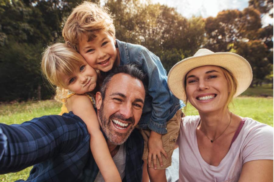 family of four hug and smile after scheduling a family dental appointment