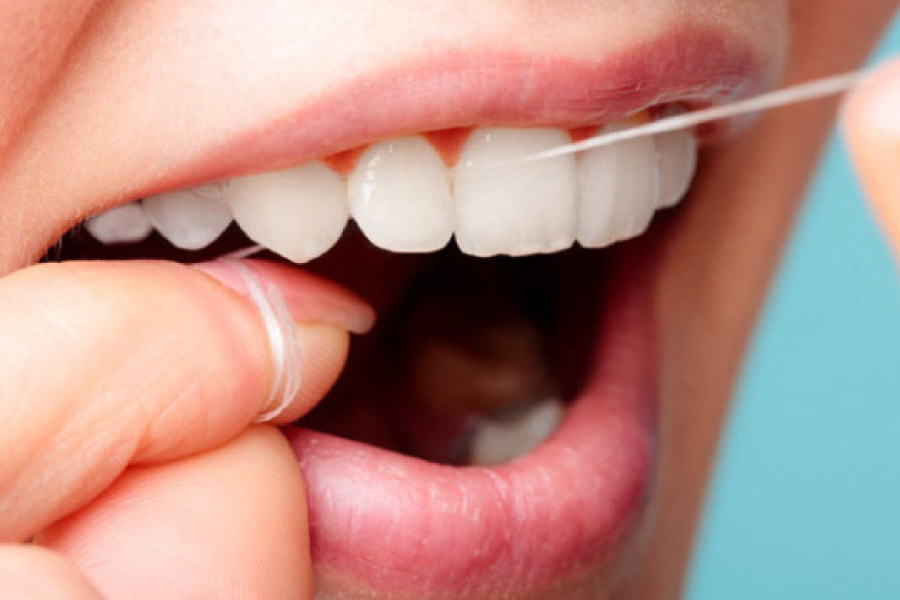close up of a woman's mouth while using dental floss