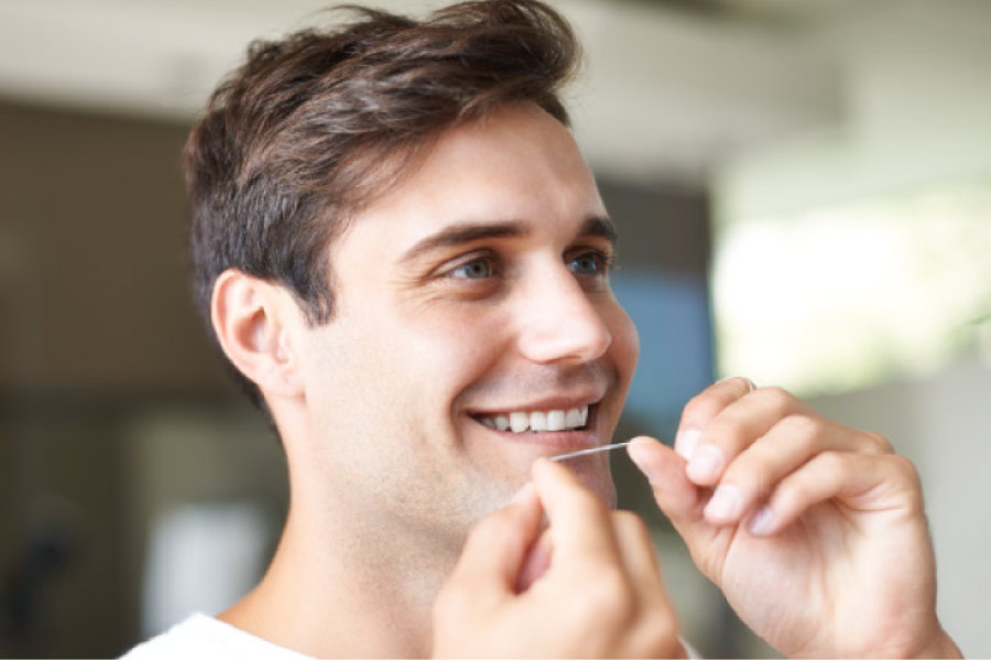 young man flossing his teeth