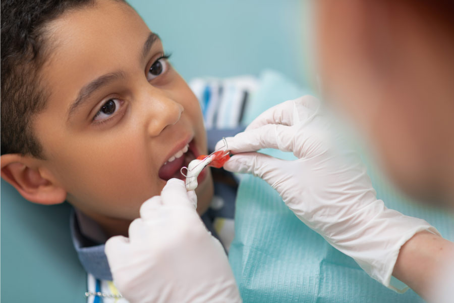 young boy gets fitted for a retainer by the orthodontist